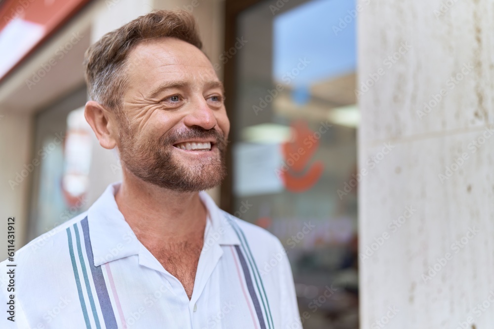 Middle age man smiling confident looking to the side at street Middle age man smiling confident looking to the side at street
