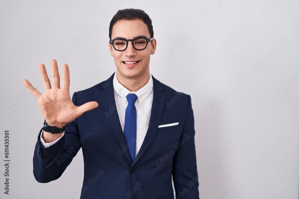 Young hispanic man wearing suit and tie showing and pointing up with fingers number five while smiling confident and happy. Young hispanic man wearing suit and tie showing and pointing up with fingers number five while smiling confident and happy.