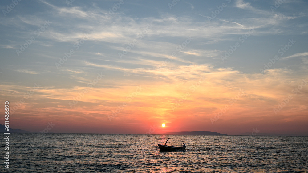 The silhouette of fishing boat at sunset. The boat on the sea.  