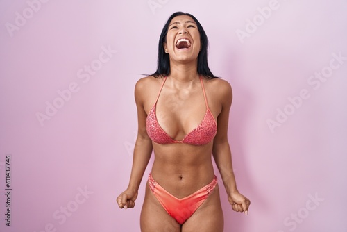 Hispanic woman wearing bikini angry and mad screaming frustrated and furious, shouting with anger. rage and aggressive concept.