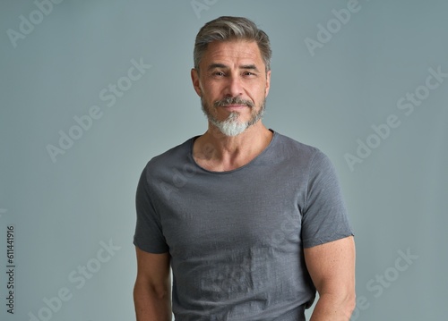 Portrait of happy casual older bearded man with gray hair smiling, Mid adult, mature age guy standing, isolated on gray background.