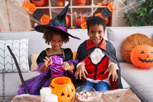 Adorable african american boy and girl wearing halloween costume doing fear gesture at home