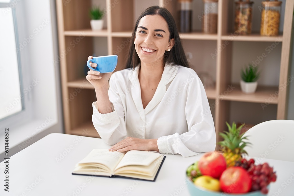 Young hispanic woman reading book drinking coffee at home Young hispanic woman reading book drinking coffee at home