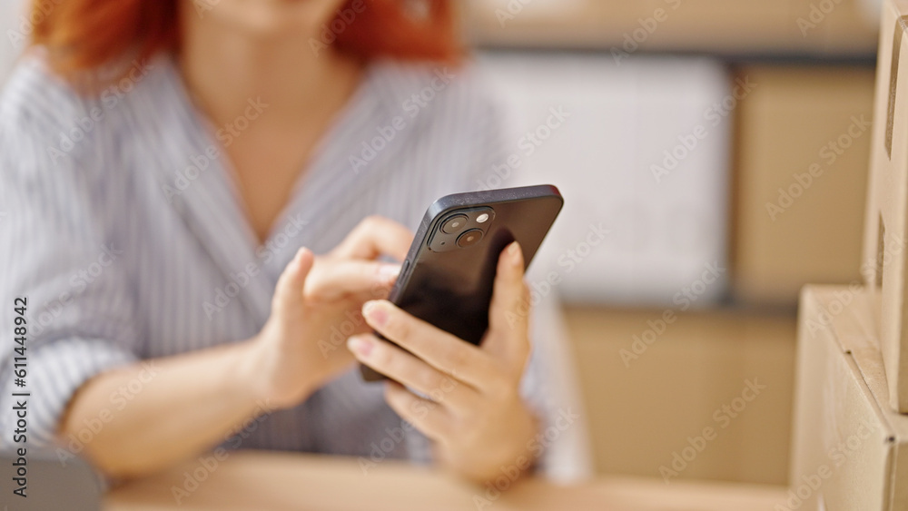 Young redhead woman ecommerce business worker using smartphone at office Young redhead woman ecommerce business worker using smartphone at office
