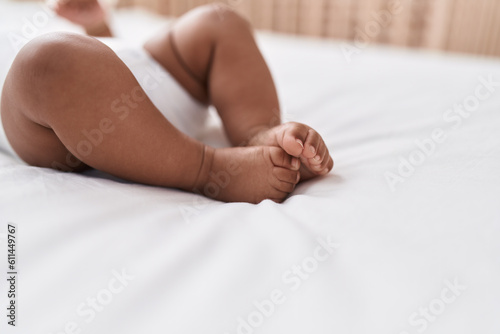 African american baby lying on bed at bedroom