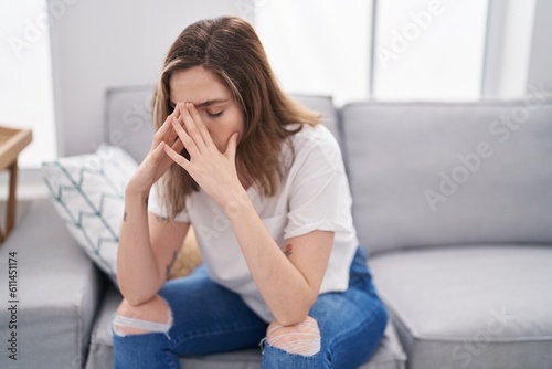 Young woman stressed sitting on sofa at home