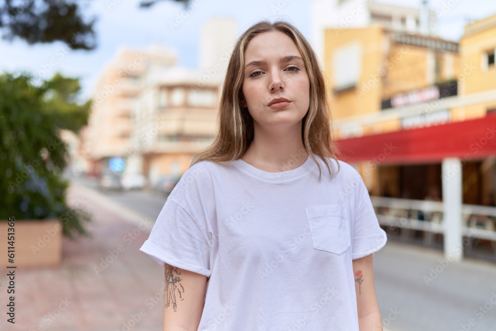 Young caucasian woman standing with serious expression at street
