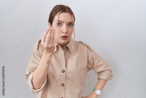 Young caucasian woman wearing casual shirt doing italian gesture with hand and fingers confident expression