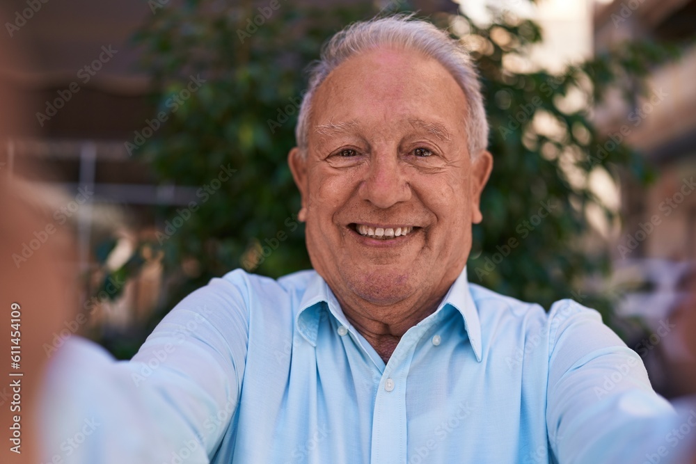 Middle age grey-haired man smiling confident making selfie by camera at street Middle age grey-haired man smiling confident making selfie by camera at street