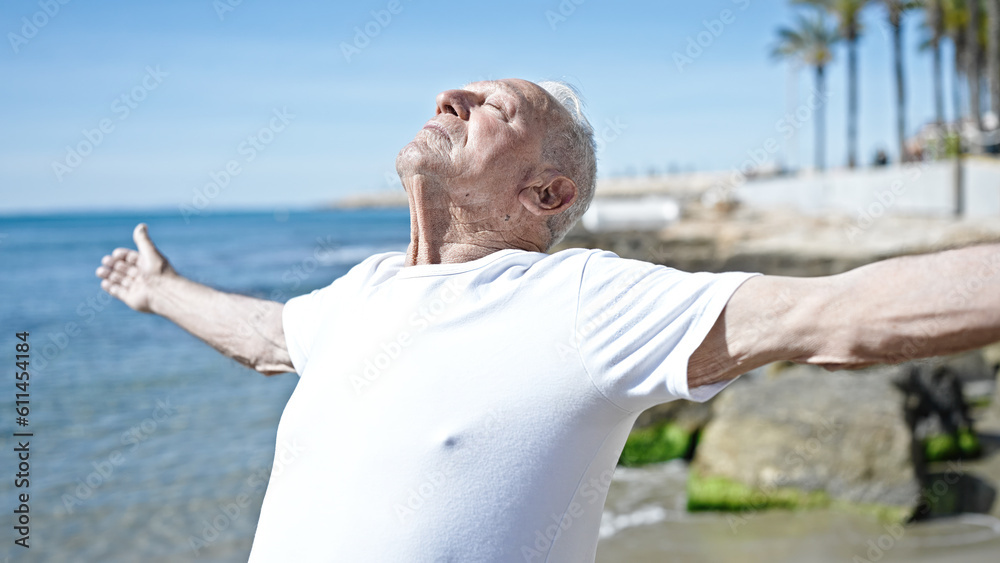 Senior grey-haired man breathing with closed eyes at seaside Senior grey-haired man breathing with closed eyes at seaside
