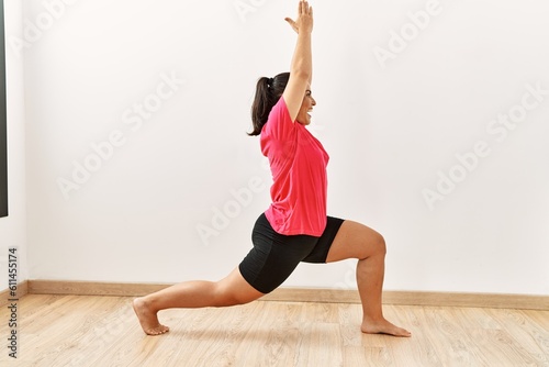 Young beautiful hispanic woman smiling confident training yoga at sport center