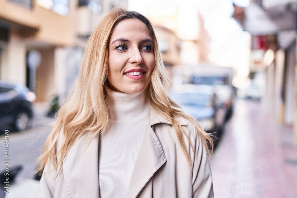 Young blonde woman smiling confident looking to the side at street Young blonde woman smiling confident looking to the side at street