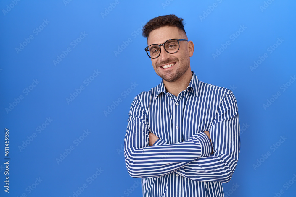 Hispanic man with beard wearing glasses happy face smiling with crossed arms looking at the camera. positive person.