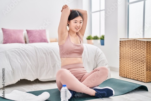 Chinese woman smiling confident stretching at bedroom