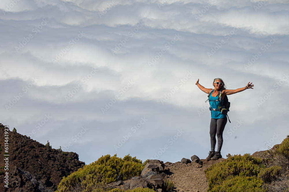 Female hiker at sunrise above the clouds at the beautiful Caldera de Taburiente National Park in La Palma - Canary Islands Female hiker at sunrise above the clouds at the beautiful Caldera de Taburiente National Park in La Palma - Canary Islands