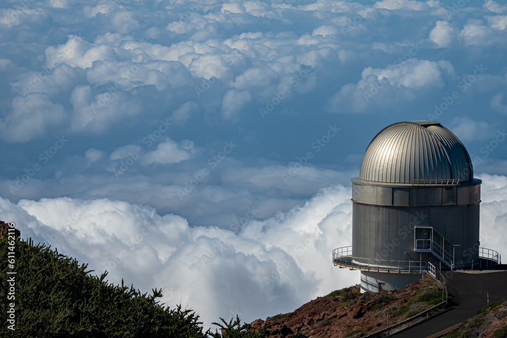 Fototapeta premium Large telescope at summit of mountain above the clouds 
