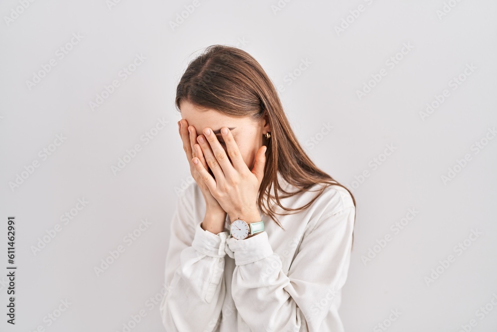 Young caucasian woman standing over isolated background with sad expression covering face with hands while crying. depression concept.