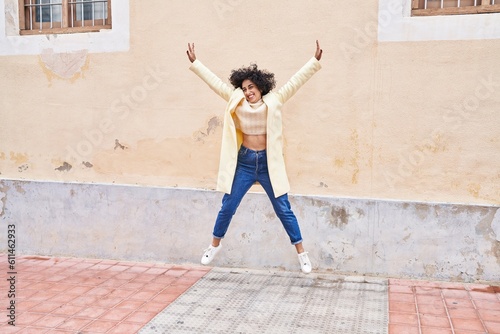 Young middle east woman excutive smiling confident jumping at street