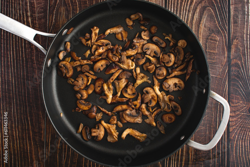 Browned Wild Mushrooms in a Non-stick Saute Pan Viewed from Above: Overhead view of oyster, shiitake, and crimini mushrooms cooked in butter photo