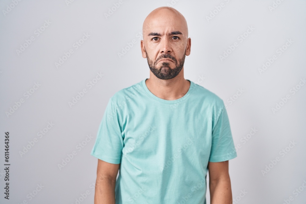 Middle age bald man standing over white background depressed and worry for distress, crying angry and afraid. sad expression. Middle age bald man standing over white background depressed and worry for distress, crying angry and afraid. sad expression.