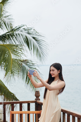 Happy young woman filming vacations vlog for her social media