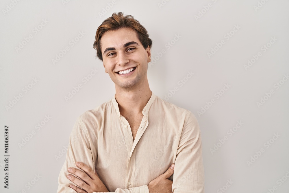 Young man standing over isolated background happy face smiling with crossed arms looking at the camera. positive person. Young man standing over isolated background happy face smiling with crossed arms looking at the camera. positive person.