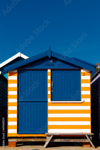 Beach Hut with orange and white stripes against a blue sky
