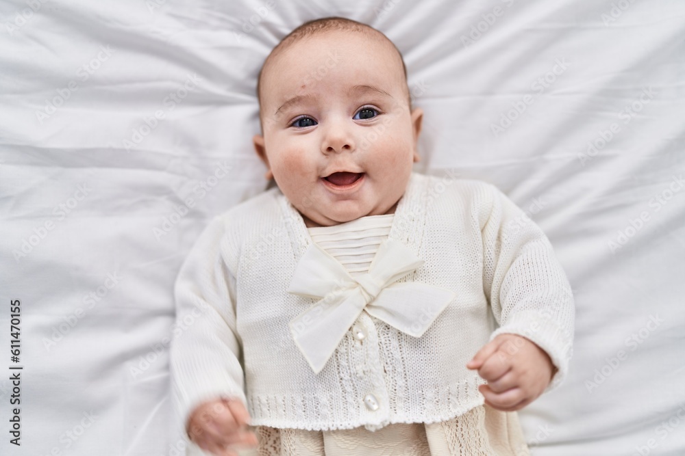 Adorable baby smiling confident lying on bed at bedroom Adorable baby smiling confident lying on bed at bedroom