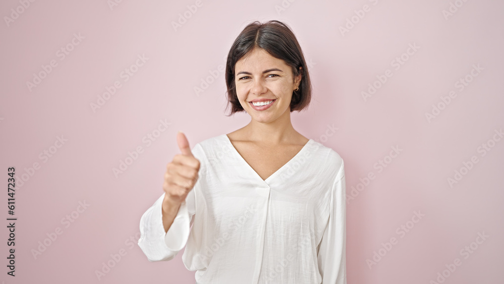 Young beautiful hispanic woman smiling with thumb up over isolated pink background Young beautiful hispanic woman smiling with thumb up over isolated pink background