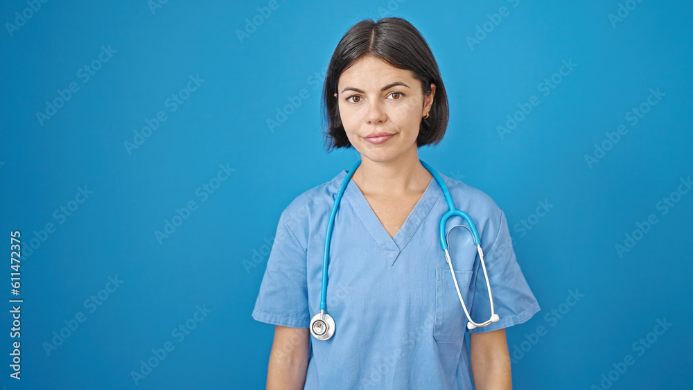 Young beautiful hispanic woman doctor standing with serious expression over isolated blue background Young beautiful hispanic woman doctor standing with serious expression over isolated blue background