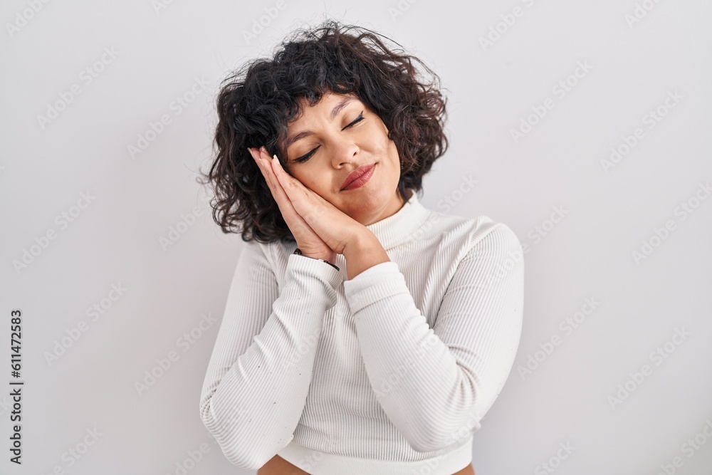 Hispanic woman with curly hair standing over isolated background sleeping tired dreaming and posing with hands together while smiling with closed eyes. Hispanic woman with curly hair standing over isolated background sleeping tired dreaming and posing with hands together while smiling with closed eyes.