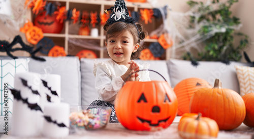 Adorable hispanic girl wearing halloween costume clapping hands at home