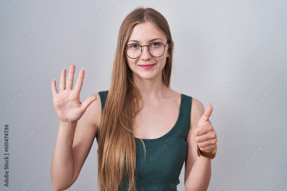 Young caucasian woman standing over white background showing and pointing up with fingers number six while smiling confident and happy. Young caucasian woman standing over white background showing and pointing up with fingers number six while smiling confident and happy.