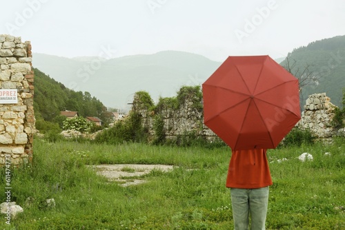 Person with red umbrella on the hill