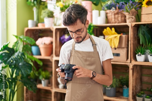 Young hispanic man florist make photo to bouquet of flowers gift at flower shop