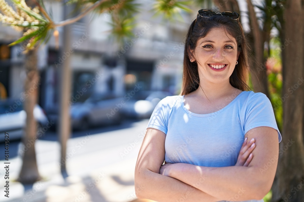 Young hispanic woman smiling confident standing with arms crossed gesture at street
