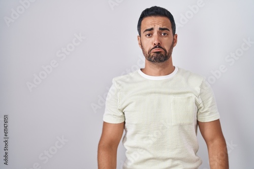 Hispanic man with beard standing over isolated background depressed and worry for distress, crying angry and afraid. sad expression. © Krakenimages.com