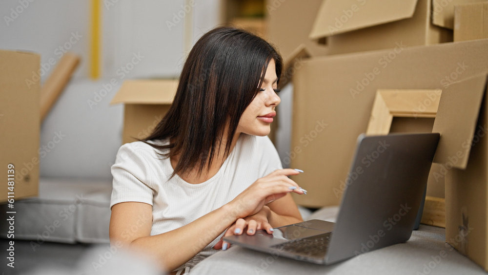 Young caucasian woman using laptop sitting on floor at new home Young caucasian woman using laptop sitting on floor at new home