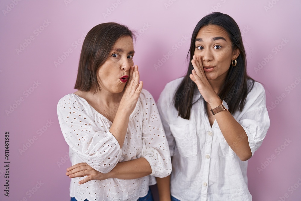 Hispanic mother and daughter together hand on mouth telling secret rumor, whispering malicious talk conversation Hispanic mother and daughter together hand on mouth telling secret rumor, whispering malicious talk conversation