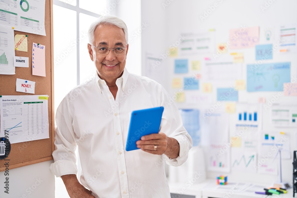 Middle age grey-haired man business worker smiling confident using touchpad at office Middle age grey-haired man business worker smiling confident using touchpad at office