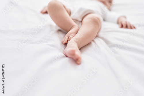 Adorable caucasian baby lying on bed at bedroom