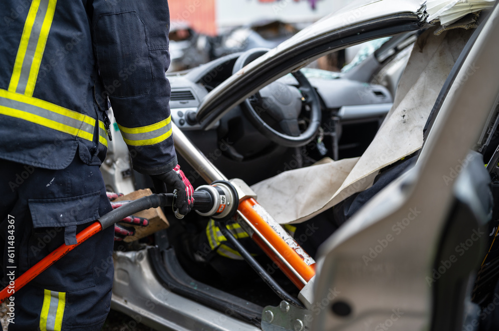 Firefighters using hydraulic tools during a rescue operation training. Rescuers unlock the passenger in car after accident. High quality photography. Firefighters using hydraulic tools during a rescue operation training. Rescuers unlock the passenger in car after accident. High quality photography.