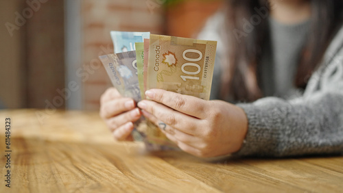 Hands of woman counting canadian dollars at room photo