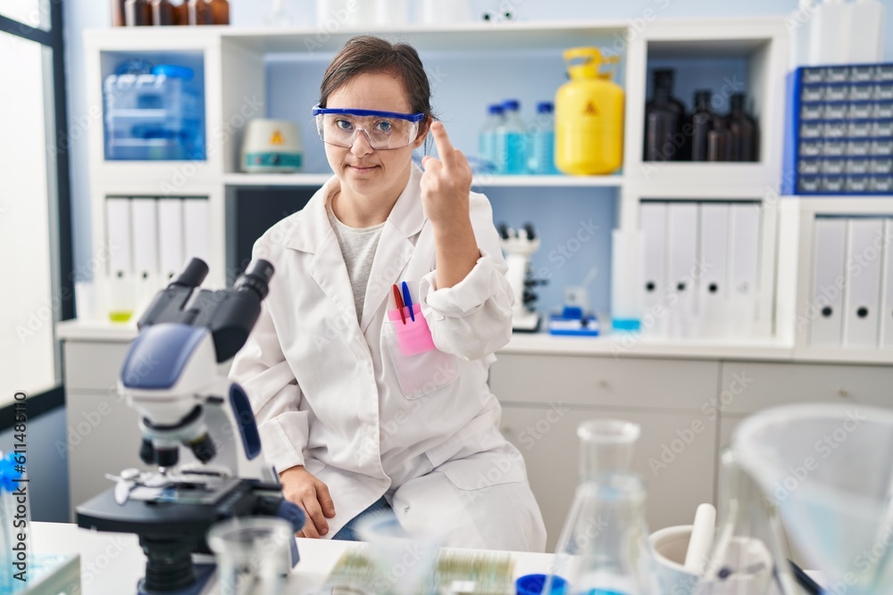 Hispanic girl with down syndrome working at scientist laboratory showing middle finger, impolite and rude fuck off expression Hispanic girl with down syndrome working at scientist laboratory showing middle finger, impolite and rude fuck off expression
