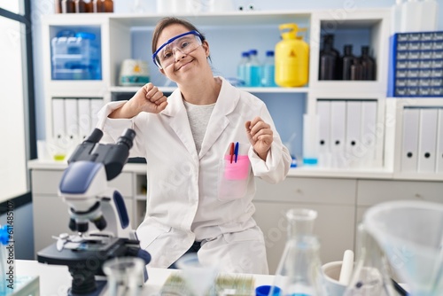 Hispanic girl with down syndrome working at scientist laboratory dancing happy and cheerful  smiling moving casual and confident listening to music