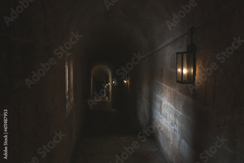 Dark mysterious corridor with attached lanterns on the wall