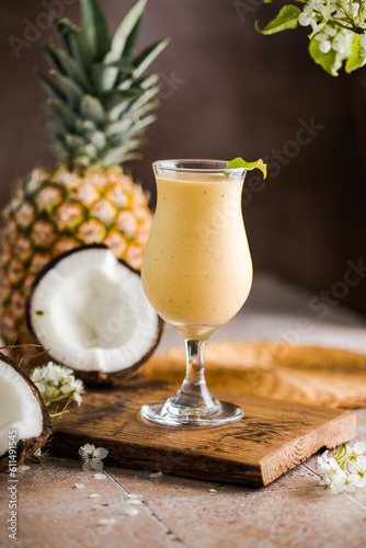 Pina colada pineapple cocktail or Lassi on a rustic wooden table