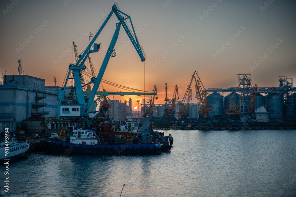 Logistics and transportation of Container Cargo ship and Cargo plane with working crane bridge in shipyard at sunrise, logistic import export and transport industry background, Aerial view from drone