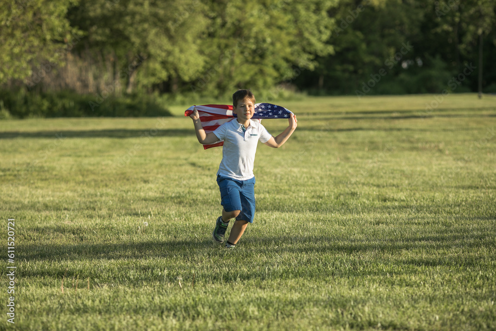 Fototapeta premium Kid boy celebrating of July, 4 Independence Day of USA . Child running with american flag symbol of United States over wheat field.