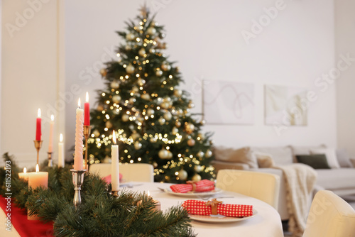 Festive table setting and beautiful Christmas decor in room. Interior design